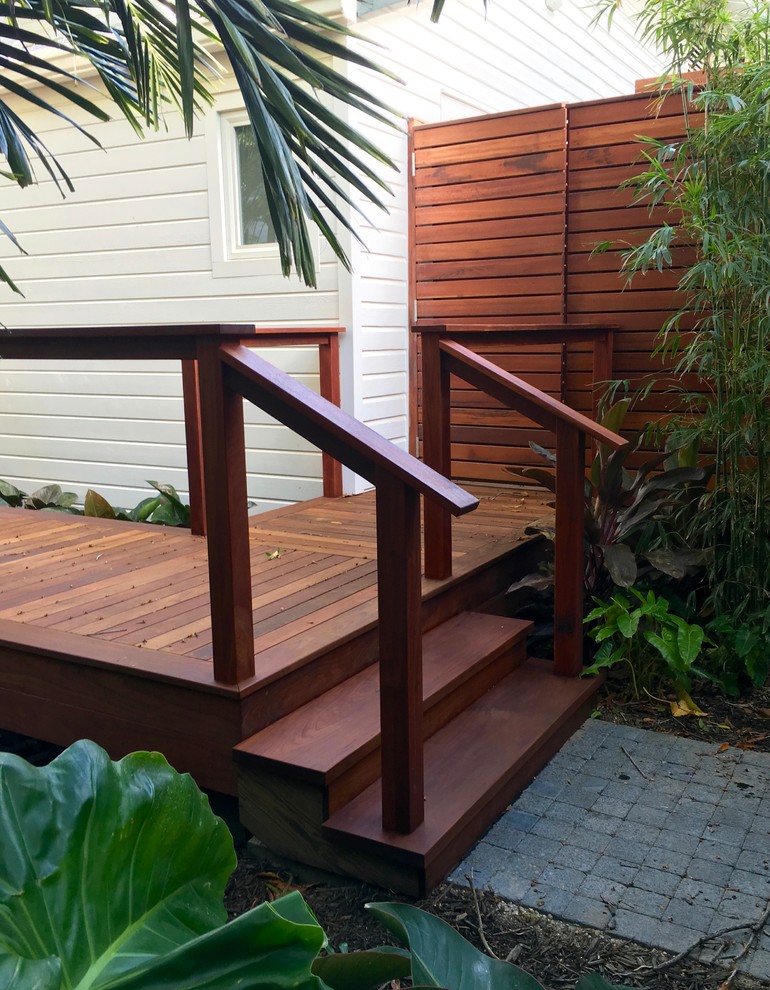 This is an example of a mid-sized tropical backyard deck in Miami with an outdoor shower and no cover.