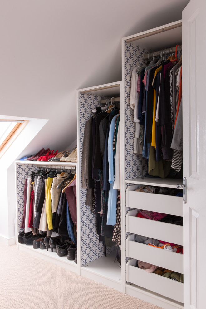 Inspiration for a small contemporary gender-neutral walk-in wardrobe in London with open cabinets, white cabinets and carpet.