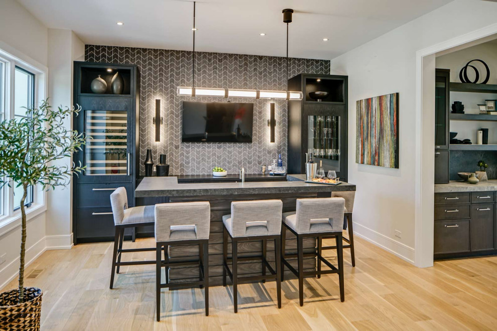 Large modern single-wall kitchen in Chicago with a submerged sink, flat-panel cabinets, dark wood cabinets, engineered stone countertops, integrated appliances, light hardwood flooring, beige floors and grey worktops.