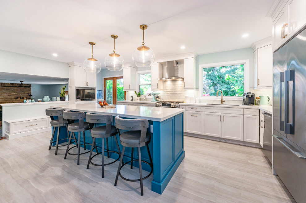 Kitchen - transitional l-shaped gray floor kitchen idea with an undermount sink, shaker cabinets, white cabinets, white backsplash, stainless steel appliances, an island and white countertops