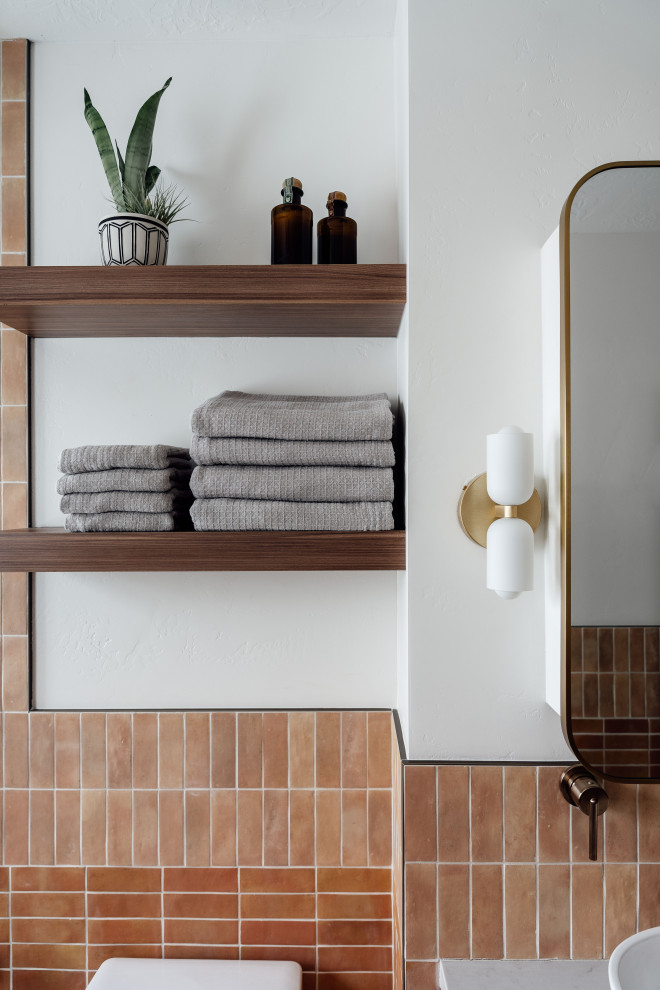 Aménagement d'une salle de bain contemporaine en bois foncé avec un combiné douche/baignoire, un carrelage orange, un mur blanc, un sol rose, une cabine de douche à porte battante, un plan de toilette gris, meuble double vasque et meuble-lavabo sur pied.