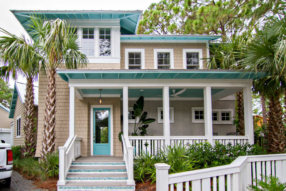 This is an example of a large beach style two-storey beige house exterior in Jacksonville with vinyl siding and a hip roof.