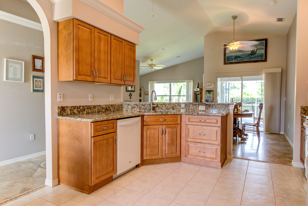 Mid-sized kitchen photo with an undermount sink, raised-panel cabinets, medium tone wood cabinets, granite countertops, white appliances and brown countertops