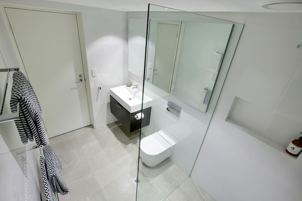 Inspiration for a mid-sized contemporary 3/4 bathroom in Melbourne with beaded inset cabinets, dark wood cabinets, an open shower, a wall-mount toilet, mosaic tile, an integrated sink and solid surface benchtops.