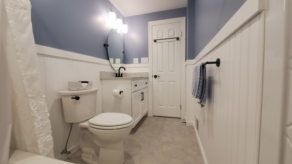 Пример оригинального дизайна: маленькая ванная комната в классическом стиле с фасадами в стиле шейкер, белыми фасадами, ванной в нише, душем над ванной, унитазом-моноблоком, белой плиткой, керамической плиткой, синими стенами, полом из керамической плитки, врезной раковиной, столешницей из искусственного кварца, серым полом, шторкой для ванной, серой столешницей, тумбой под одну раковину, встроенной тумбой и стенами из вагонки для на участке и в саду