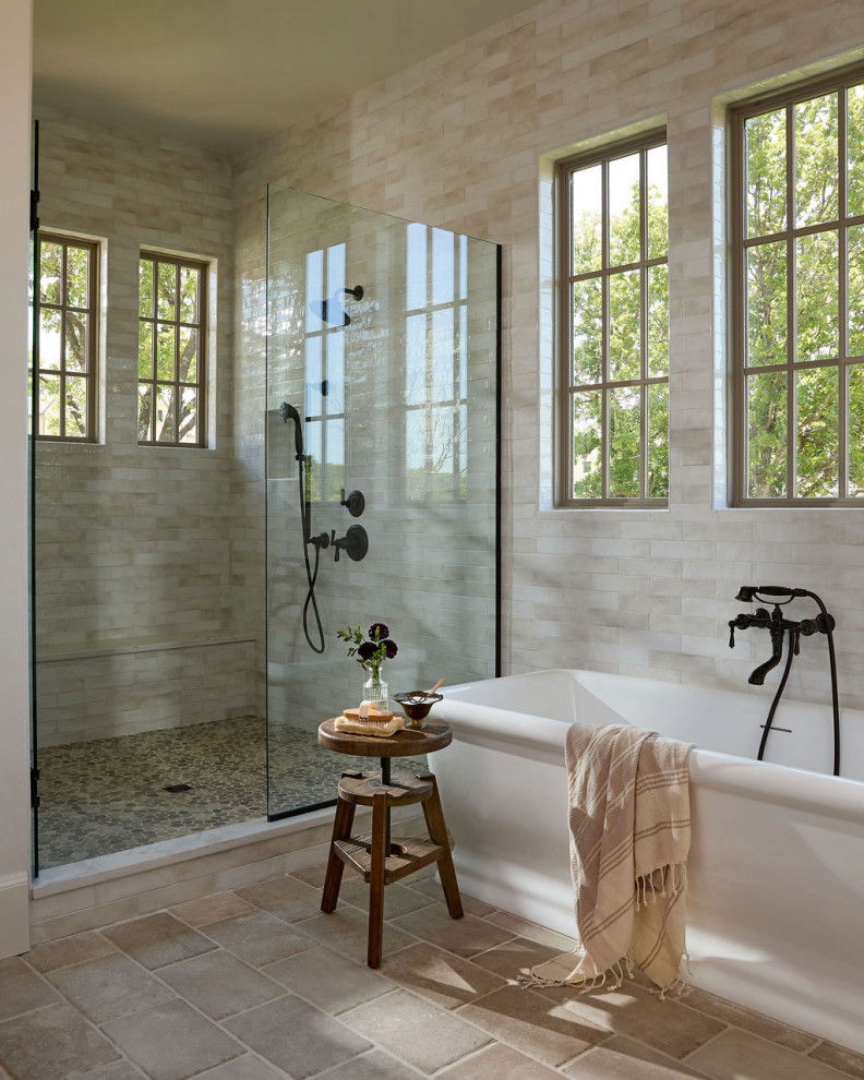 Freestanding bathtub - cottage beige tile beige floor freestanding bathtub idea in Oklahoma City with beige walls and a hinged shower door