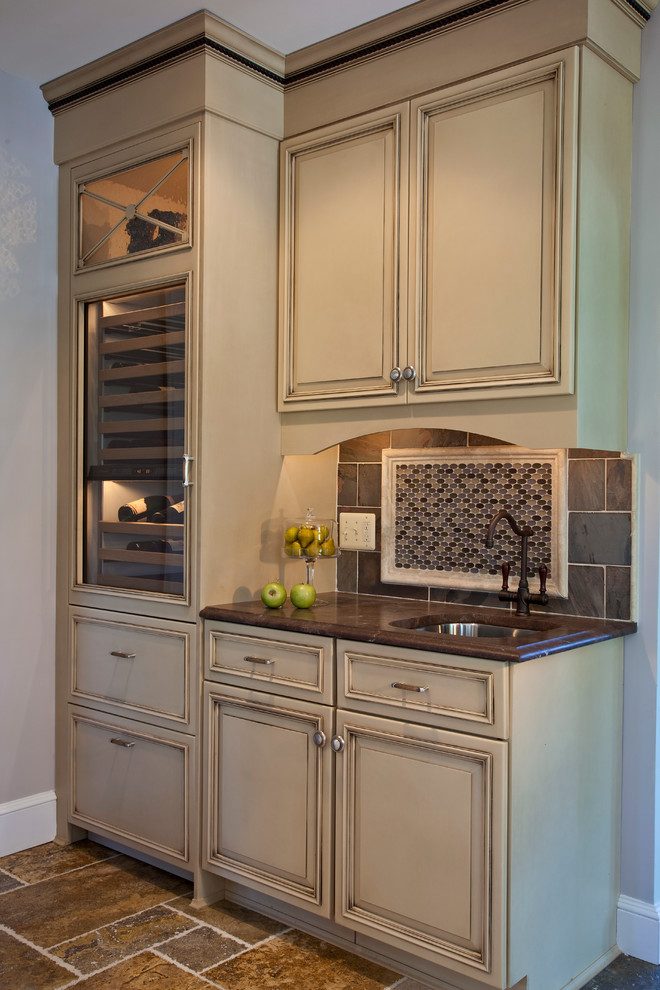 Large transitional l-shaped ceramic tile eat-in kitchen photo in Baltimore with an undermount sink, raised-panel cabinets, beige cabinets, granite countertops, brown backsplash, ceramic backsplash, stainless steel appliances and an island