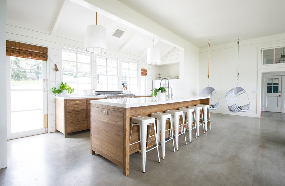 Country galley open plan kitchen in San Francisco with flat-panel cabinets, medium wood cabinets, concrete floors, with island and grey floor.