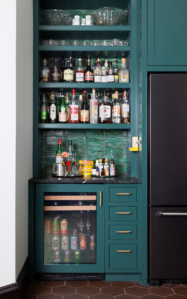 This is an example of an eclectic single-wall home bar in Austin with no sink, open cabinets, green cabinets, green splashback and brown floor.