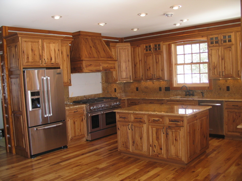Inspiration for a large rustic u-shaped light wood floor and beige floor enclosed kitchen remodel with an undermount sink, raised-panel cabinets, light wood cabinets, quartz countertops, beige backsplash, porcelain backsplash, stainless steel appliances and a peninsula