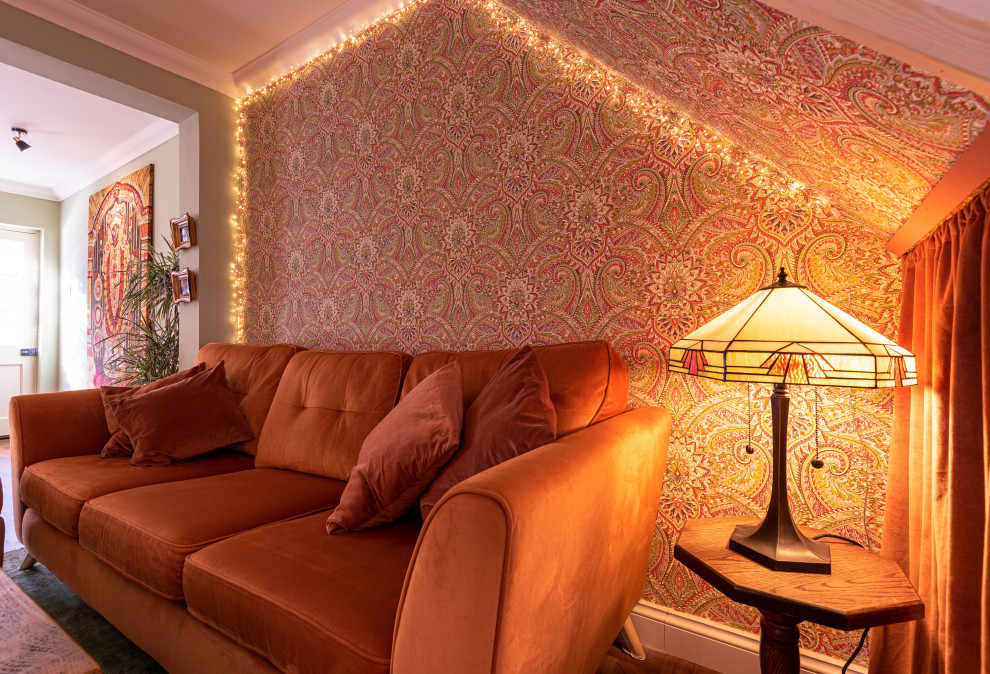 Cette photo montre un salon éclectique de taille moyenne et ouvert avec un mur vert, sol en stratifié, un téléviseur encastré, un sol marron, un plafond en papier peint et du papier peint.