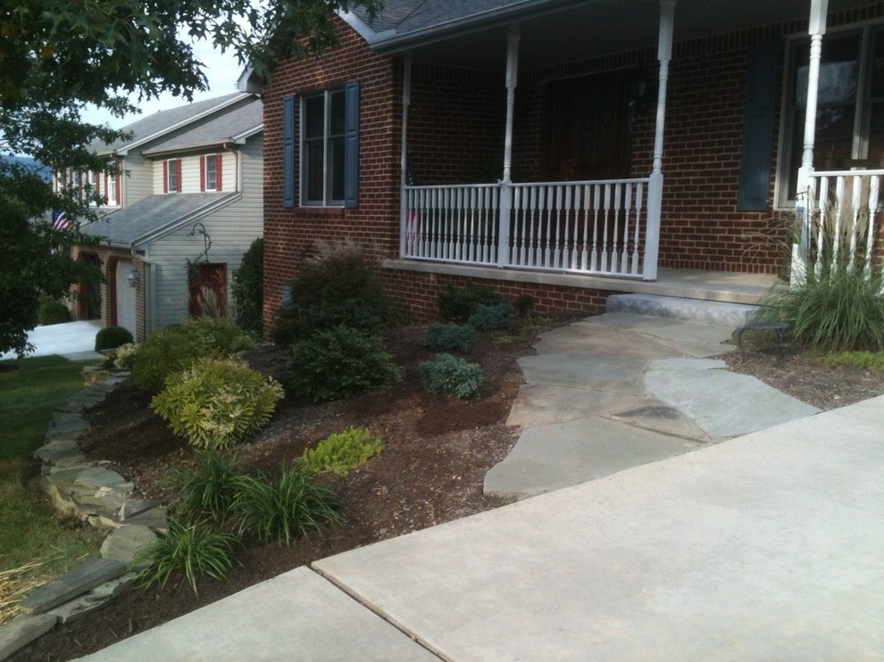 This is an example of a mid-sized transitional partial sun front yard stone landscaping in Columbus.
