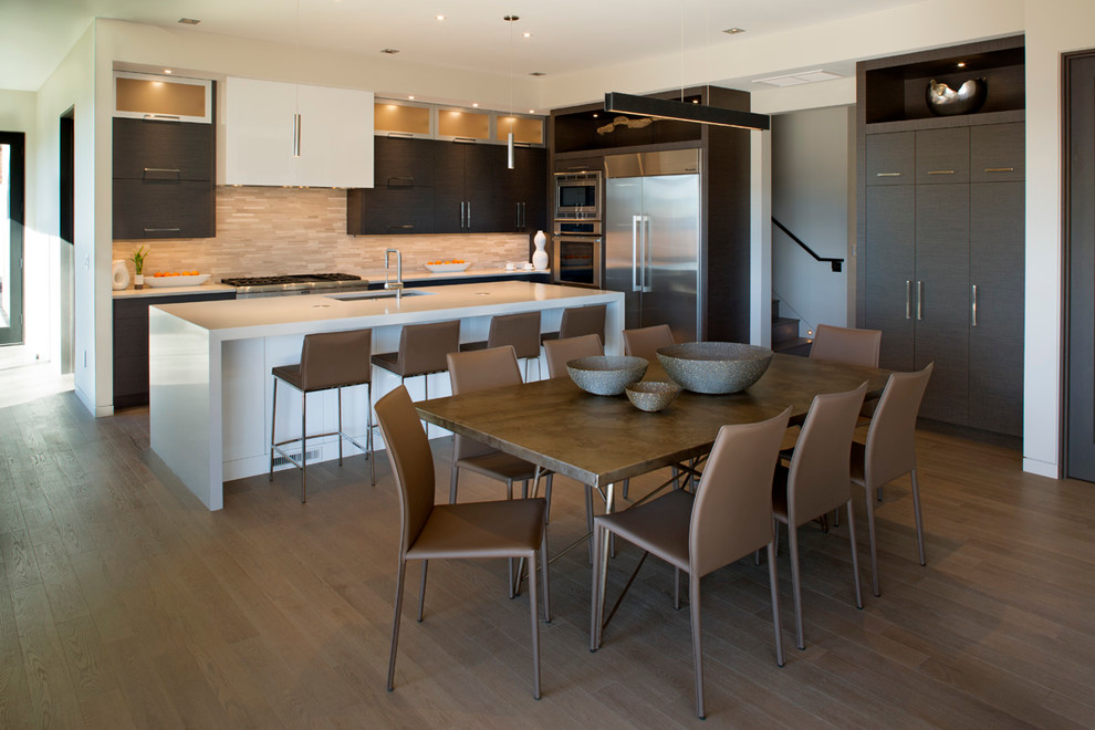Photo of a large contemporary l-shaped eat-in kitchen in Other with an undermount sink, flat-panel cabinets, dark wood cabinets, quartz benchtops, stainless steel appliances, medium hardwood floors, with island, multi-coloured splashback and matchstick tile splashback.