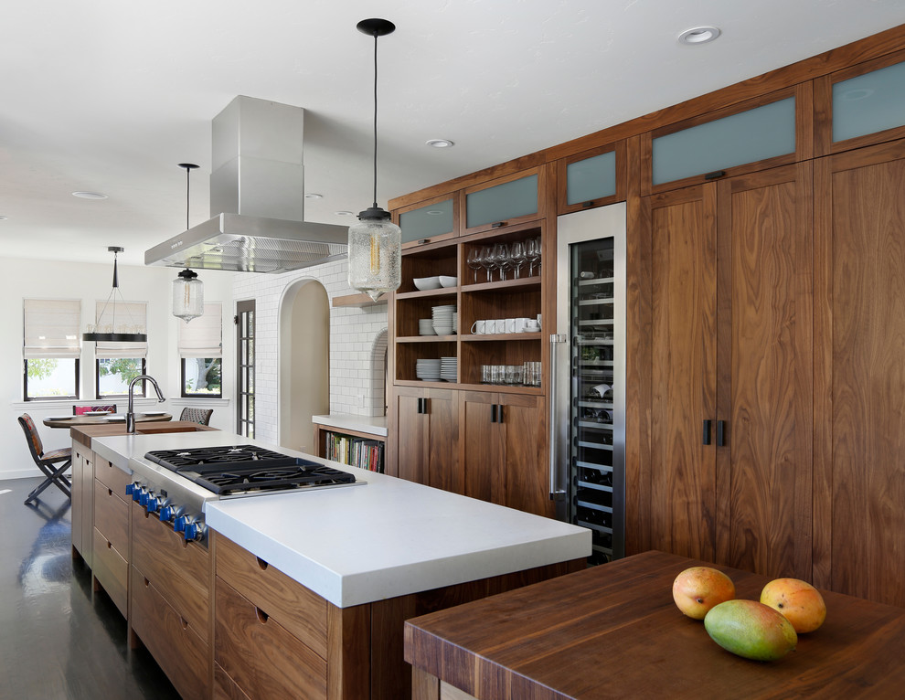 This is an example of a transitional eat-in kitchen in San Francisco with subway tile splashback, wood benchtops and dark wood cabinets.