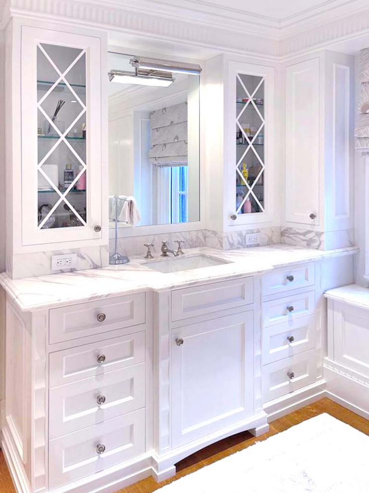 Inspiration for a mid-sized timeless master white tile medium tone wood floor, brown floor, double-sink, coffered ceiling and wood wall bathroom remodel in New York with shaker cabinets, white cabinets, a one-piece toilet, white walls, a drop-in sink, quartz countertops, white countertops and a built-in vanity