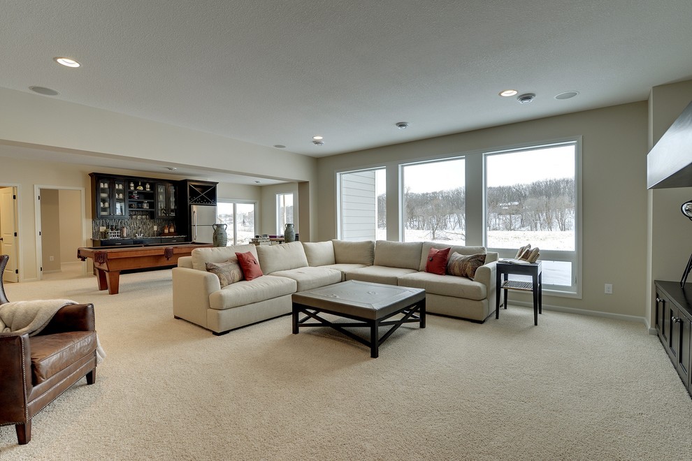 This is an example of a large transitional walk-out basement in Minneapolis with white walls and carpet.