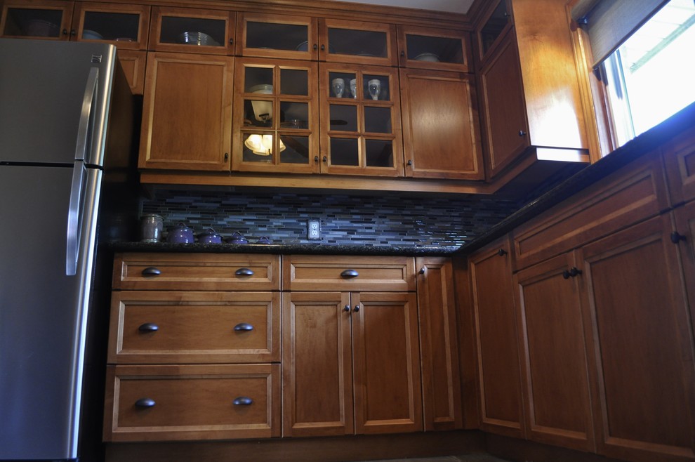 Mid-sized mountain style l-shaped kitchen photo in Toronto with an undermount sink, medium tone wood cabinets, granite countertops, blue backsplash, stainless steel appliances and no island