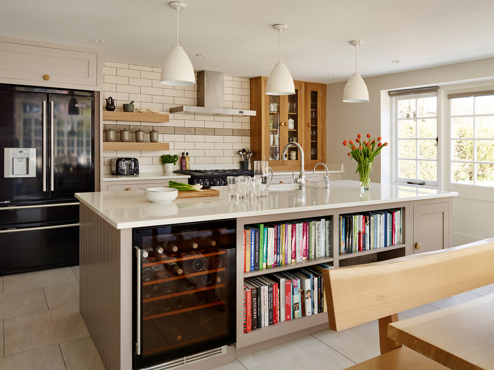 Photo of a traditional kitchen in London with with island and beige cabinets.
