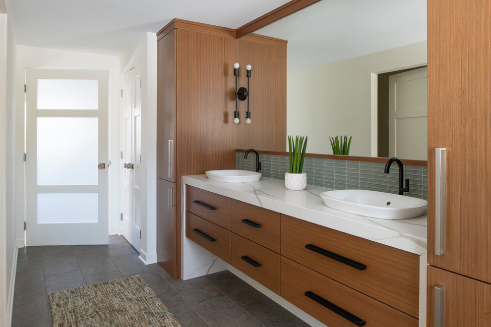 Photo of a mid-sized midcentury master bathroom in Minneapolis with flat-panel cabinets, medium wood cabinets, white tile, white walls, porcelain floors, a vessel sink, engineered quartz benchtops, grey floor, white benchtops and glass tile.