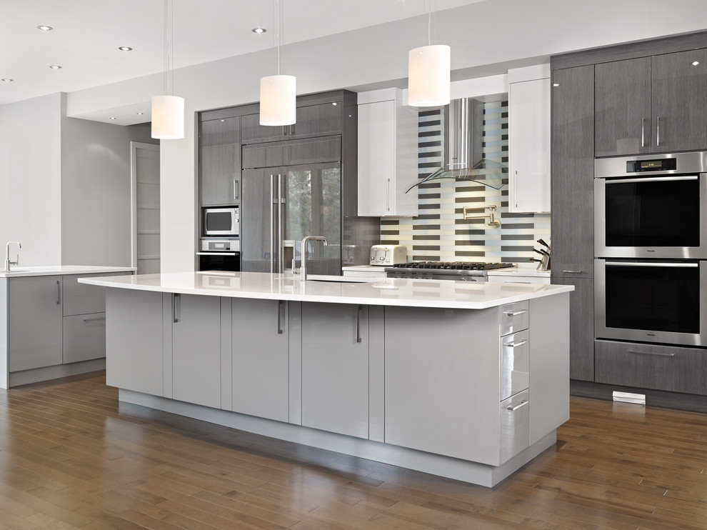 Contemporary galley kitchen in Edmonton with panelled appliances, flat-panel cabinets, grey cabinets and multi-coloured splashback.