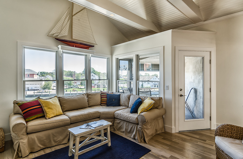 Example of a mid-sized beach style open concept light wood floor living room design in New York with white walls