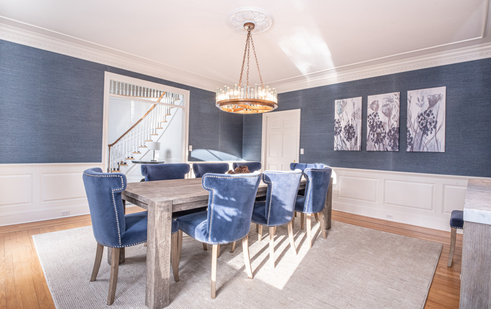 Ispirazione per una sala da pranzo chic chiusa e di medie dimensioni con pareti blu, pavimento in legno massello medio e carta da parati