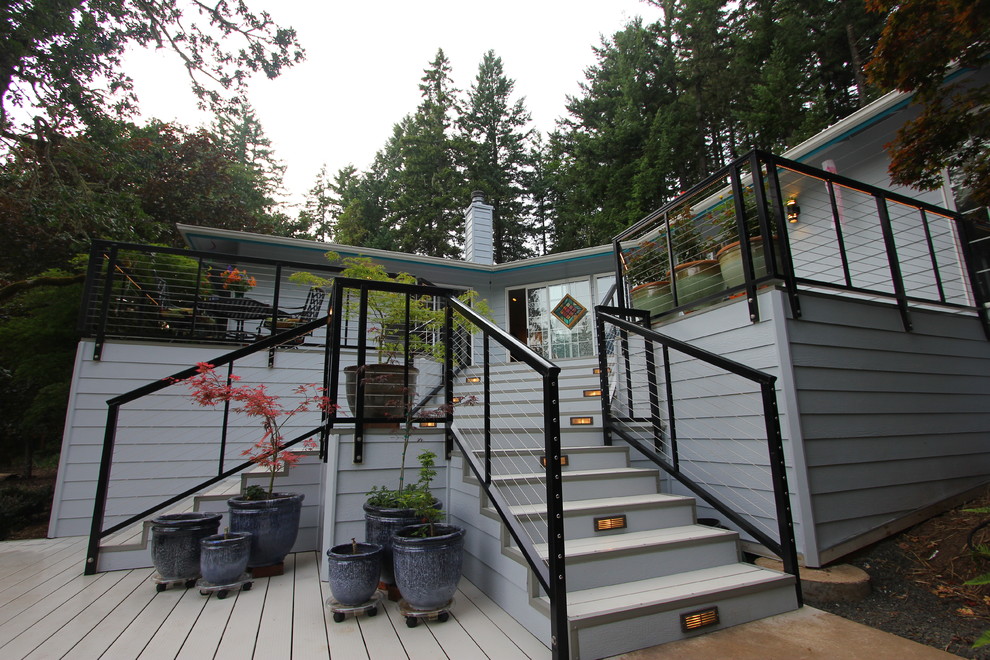 Photo of a large modern backyard deck in Other with a fire feature and no cover.