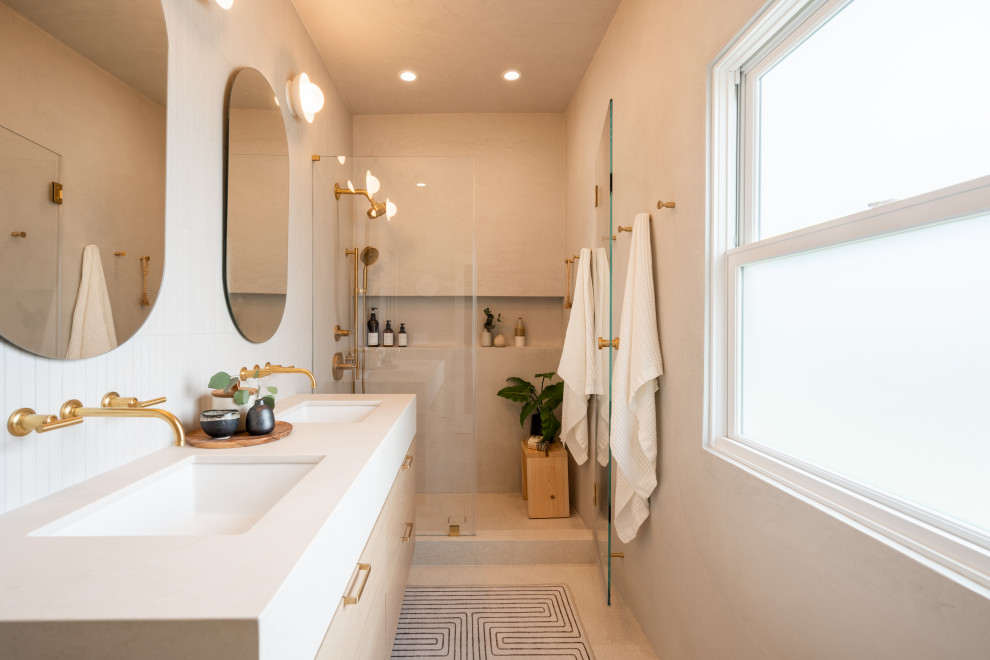 Photo of a medium sized scandinavian ensuite bathroom in San Francisco with flat-panel cabinets, an alcove shower, a wall mounted toilet, beige tiles, limestone tiles, beige walls, ceramic flooring, a submerged sink, engineered stone worktops, beige floors, a hinged door, beige worktops, a wall niche, double sinks and a floating vanity unit.