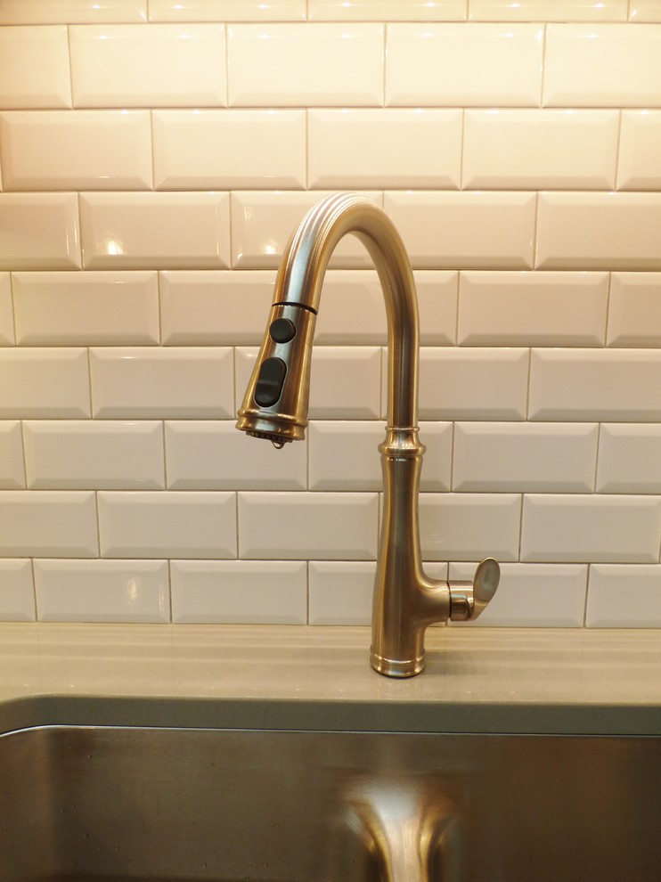 Inspiration for a transitional l-shaped porcelain tile eat-in kitchen remodel with an undermount sink, recessed-panel cabinets, medium tone wood cabinets, quartz countertops, white backsplash, subway tile backsplash, stainless steel appliances and an island