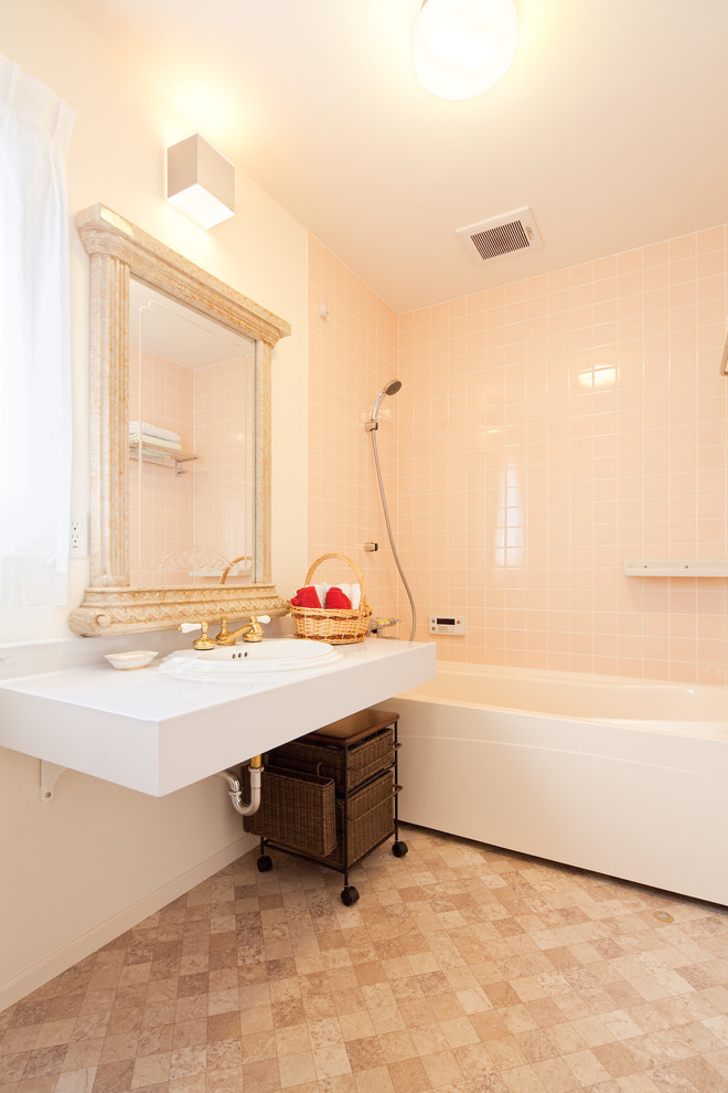 This is an example of a mid-sized traditional master bathroom in Other with brown cabinets, an alcove tub, an alcove shower, a one-piece toilet, pink tile, ceramic tile, white walls, mosaic tile floors, a drop-in sink, solid surface benchtops, beige floor, a shower curtain and white benchtops.