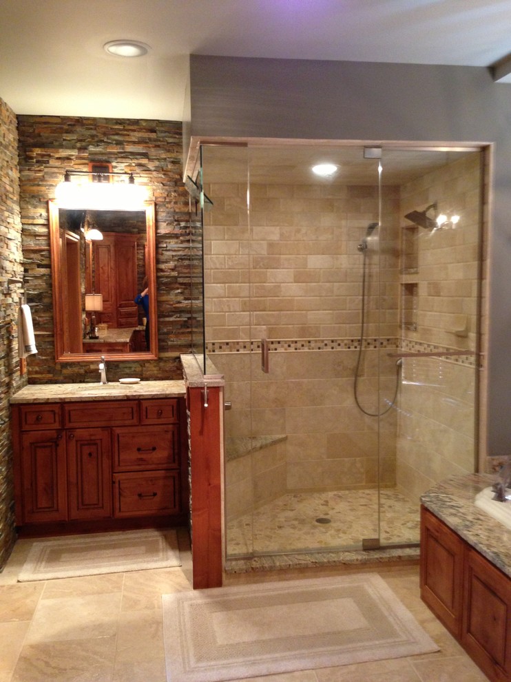 Example of a mountain style corner shower design in St Louis with raised-panel cabinets, granite countertops and medium tone wood cabinets
