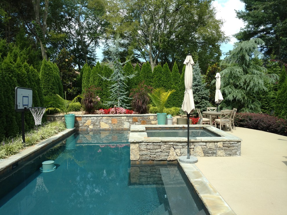Design ideas for a mid-sized traditional backyard rectangular lap pool in Nashville with a hot tub and stamped concrete.