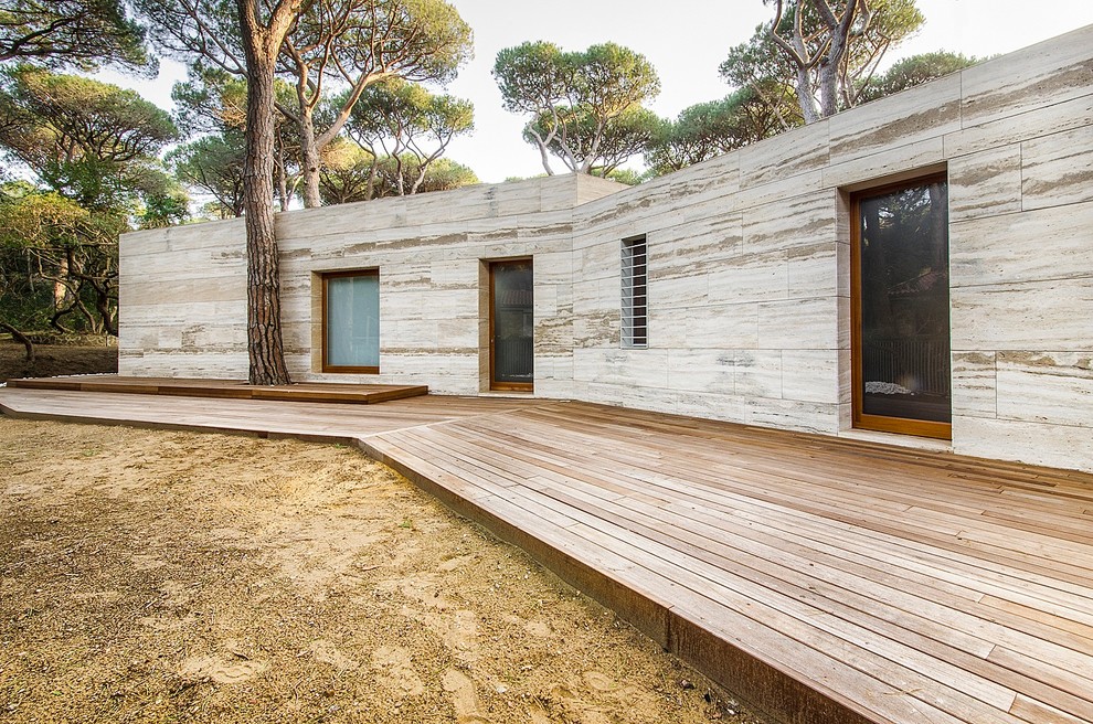 Inspiration for a contemporary one-storey beige exterior in Florence with stone veneer and a flat roof.