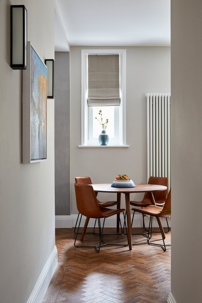 Photo of a contemporary dining room in London with grey walls, dark hardwood floors and brown floor.
