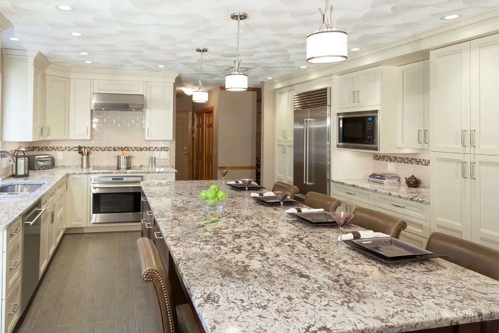 Eat-in kitchen - transitional u-shaped eat-in kitchen idea in Providence with an undermount sink, shaker cabinets, beige cabinets, granite countertops, beige backsplash, subway tile backsplash and stainless steel appliances