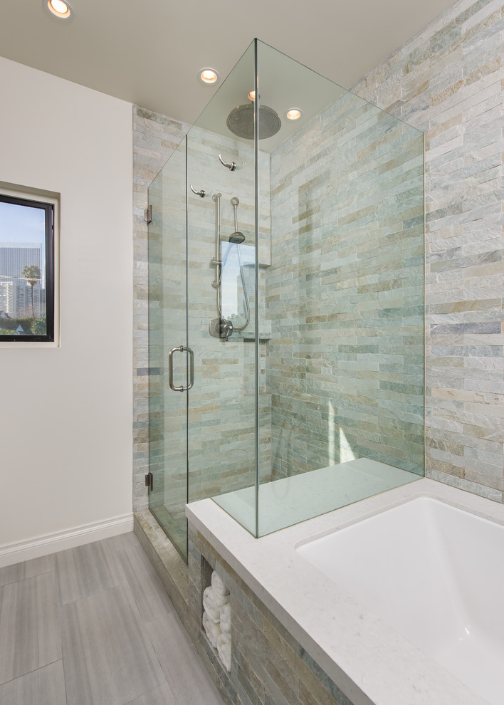 Design ideas for a small traditional master bathroom in Los Angeles with raised-panel cabinets, a drop-in tub, a corner shower, a one-piece toilet, multi-coloured tile, stone tile, white walls, porcelain floors, an undermount sink and engineered quartz benchtops.