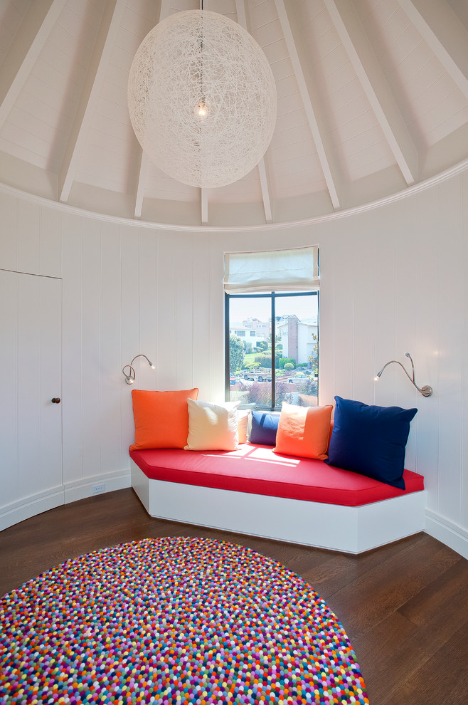 This is an example of a contemporary gender-neutral kids' playroom in San Francisco with white walls and dark hardwood floors.
