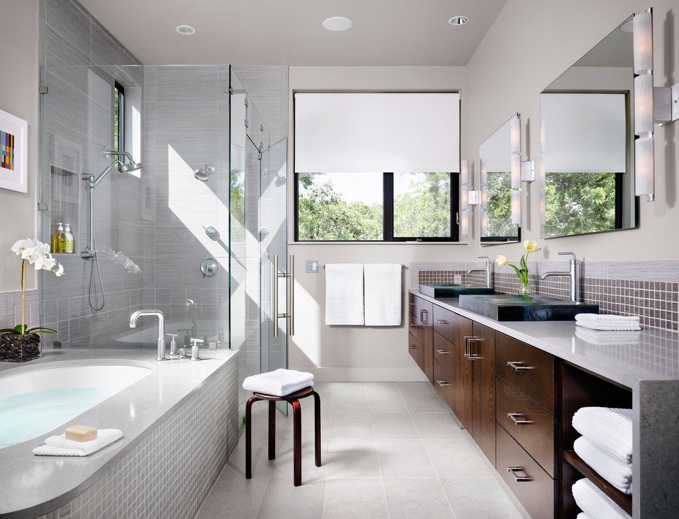 This is an example of a mid-sized contemporary master bathroom in Austin with dark wood cabinets, an undermount tub, flat-panel cabinets, a corner shower, gray tile, mosaic tile, grey walls, ceramic floors, a trough sink, engineered quartz benchtops and grey benchtops.