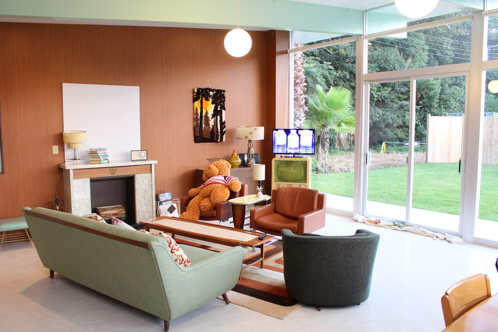 This is an example of a midcentury living room in Other with brown walls, a freestanding tv and beige floor.