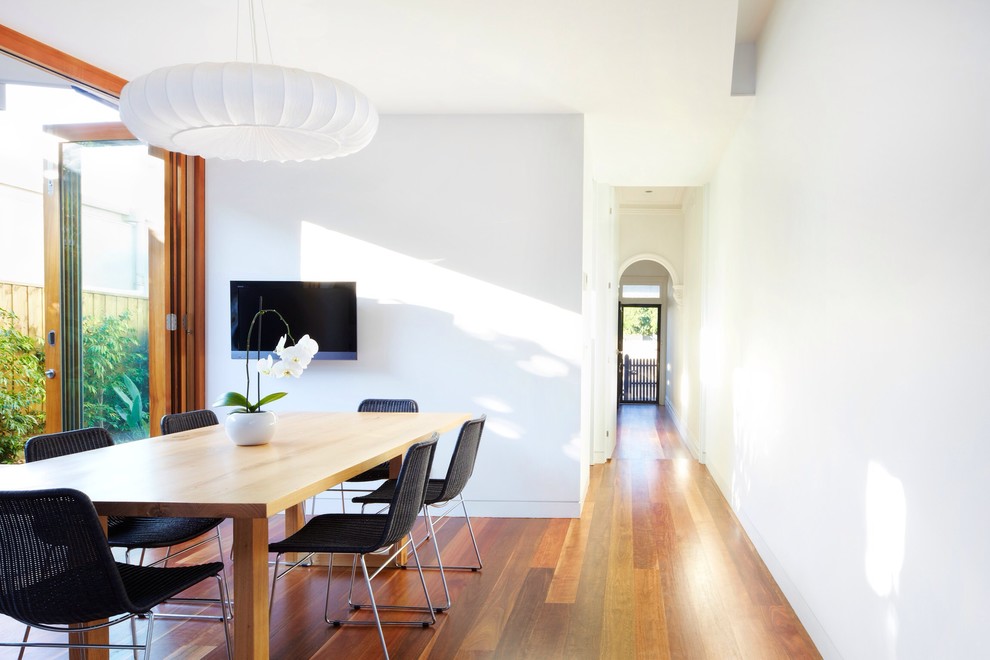 Contemporary dining room in Melbourne with white walls and dark hardwood floors.