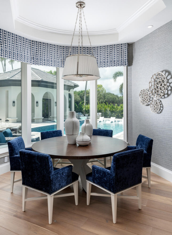 This is an example of an expansive transitional dining room in Miami with blue walls, medium hardwood floors, brown floor and wallpaper.