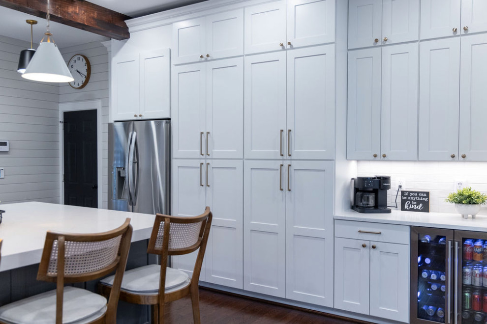 Inspiration for a large transitional u-shaped medium tone wood floor kitchen remodel in DC Metro with a single-bowl sink, flat-panel cabinets, quartz countertops, white backsplash, porcelain backsplash, stainless steel appliances, an island and white countertops