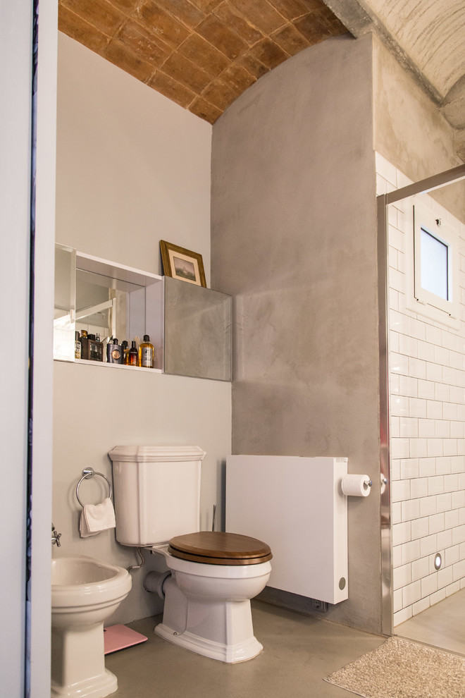 This is an example of a small industrial powder room in Barcelona with a bidet.