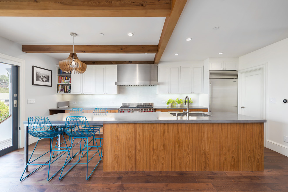 Mid-sized transitional galley open plan kitchen in San Francisco with a double-bowl sink, shaker cabinets, white cabinets, white splashback, stainless steel appliances, dark hardwood floors and with island.