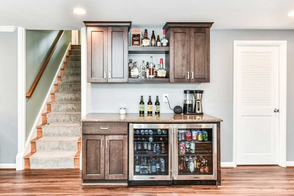Design ideas for a large transitional single-wall home bar in DC Metro with laminate floors, brown floor, shaker cabinets, brown cabinets, granite benchtops and multi-coloured benchtop.