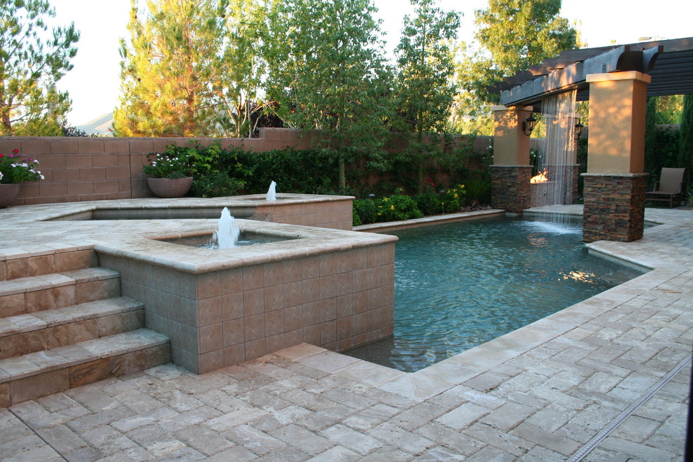 Design ideas for a large mediterranean backyard patio in Las Vegas with a water feature, natural stone pavers and a pergola.