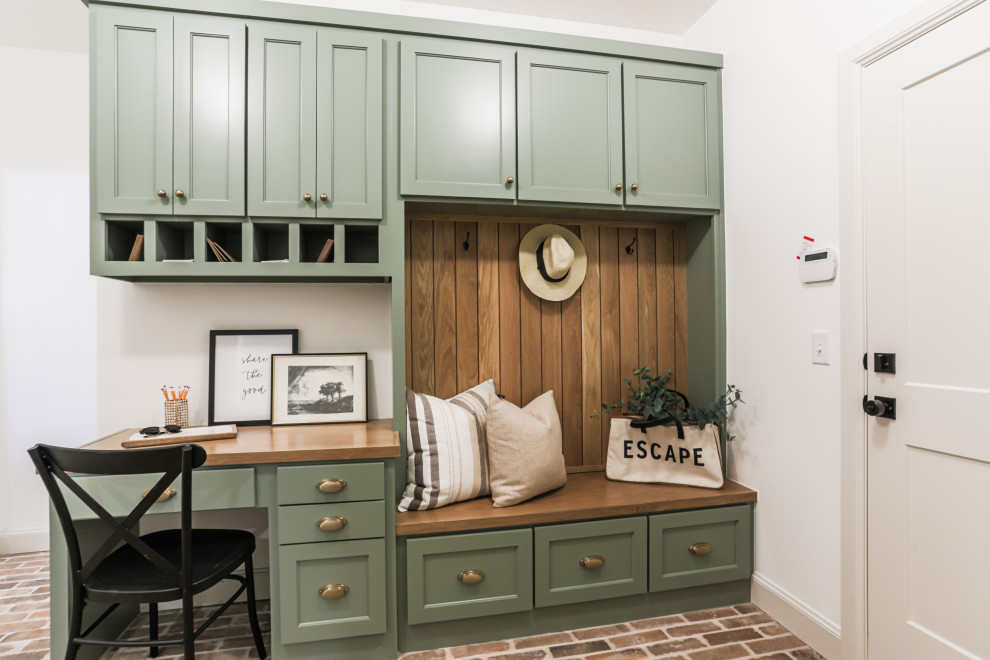 Inspiration for a large traditional galley dedicated laundry room in Oklahoma City with shaker cabinets, green cabinets, wood benchtops, brick floors, a side-by-side washer and dryer, red floor and brown benchtop.