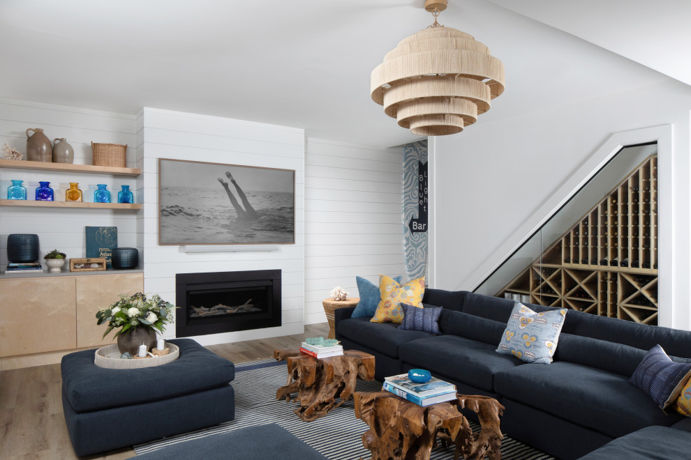 Inspiration for a large beach style walk-out basement in New York with white walls, vinyl floors, a standard fireplace, brown floor and planked wall panelling.