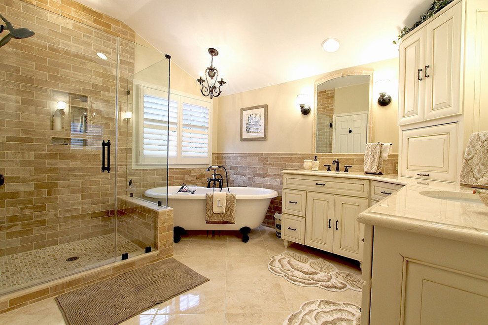 Large master bathroom in DC Metro with an undermount sink, furniture-like cabinets, white cabinets, quartzite benchtops, a claw-foot tub, a corner shower, a two-piece toilet, beige tile, stone tile, beige walls and travertine floors.