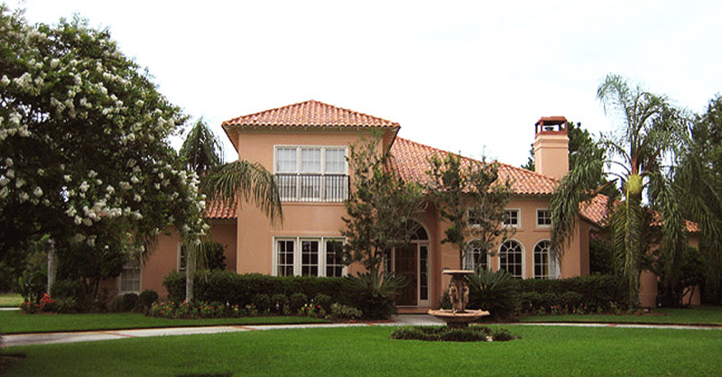 Design ideas for a mid-sized mediterranean two-storey stucco beige exterior in New Orleans.